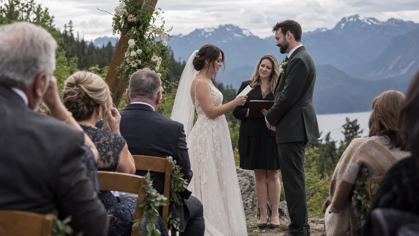 An outdoor mountain wedding ceremony seen through the seated guests