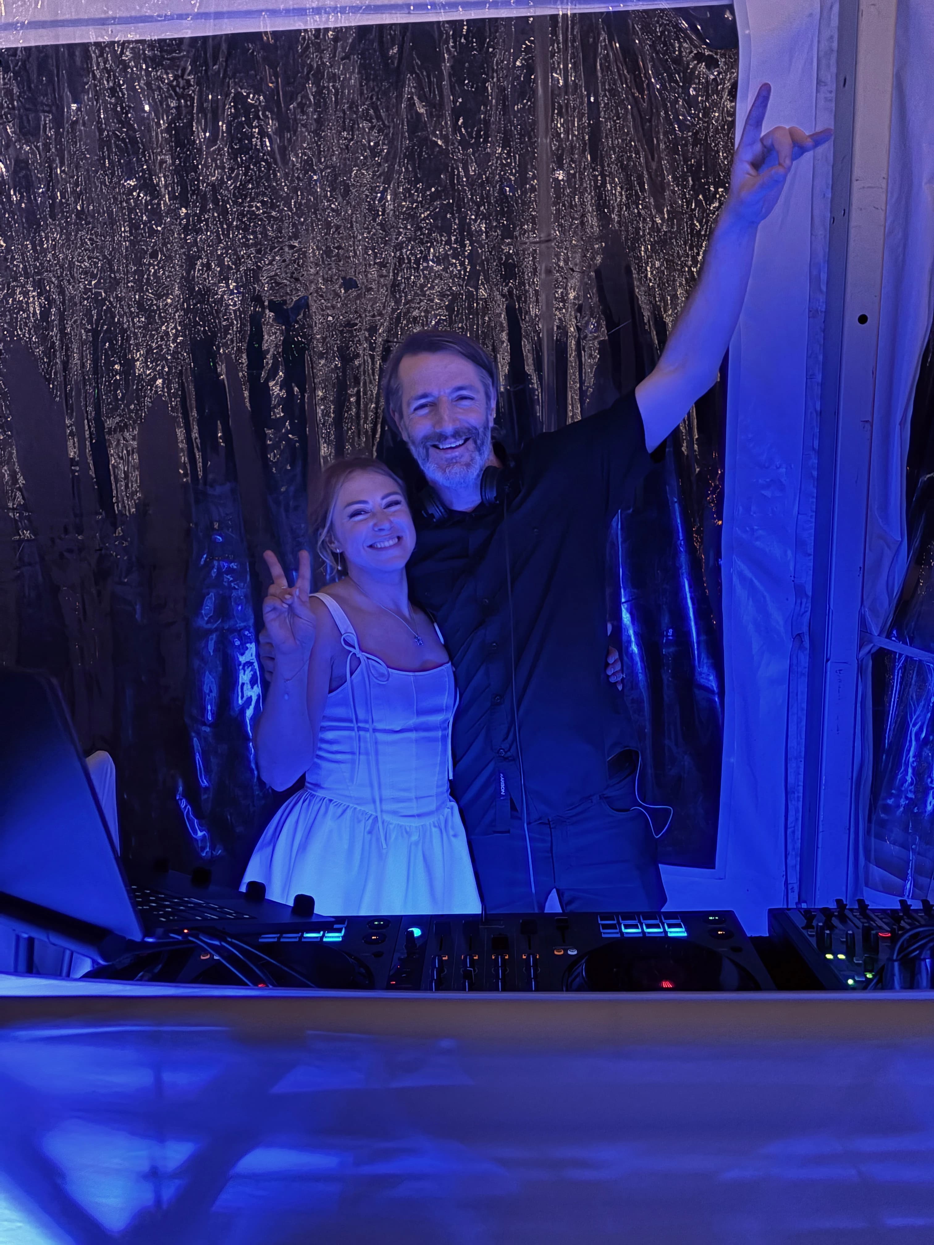 Patrick with a bride behind his DJ controller at a real wedding reception