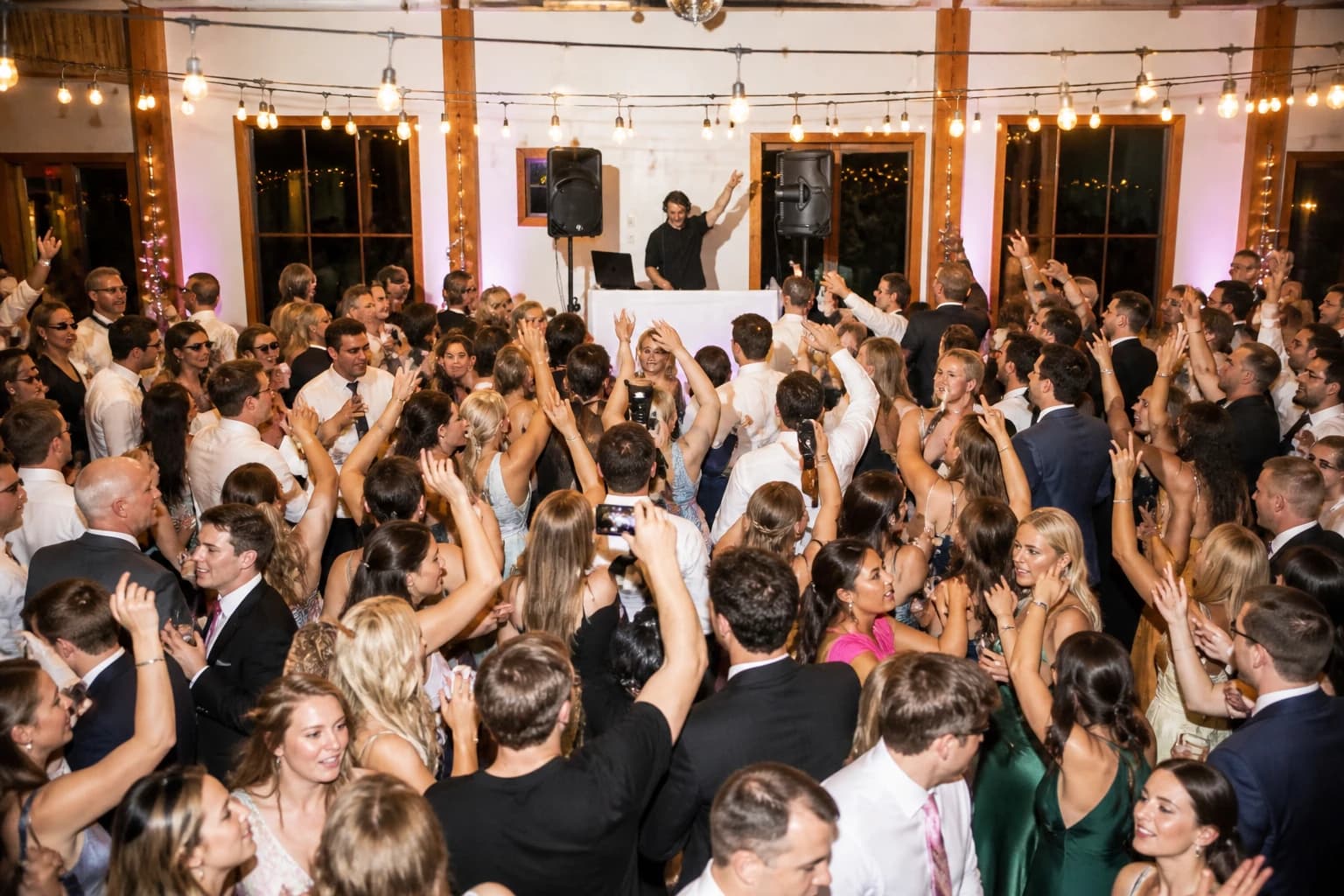 Editorial wedding dance floor scene with Howe Sound DJ energy and a packed reception crowd